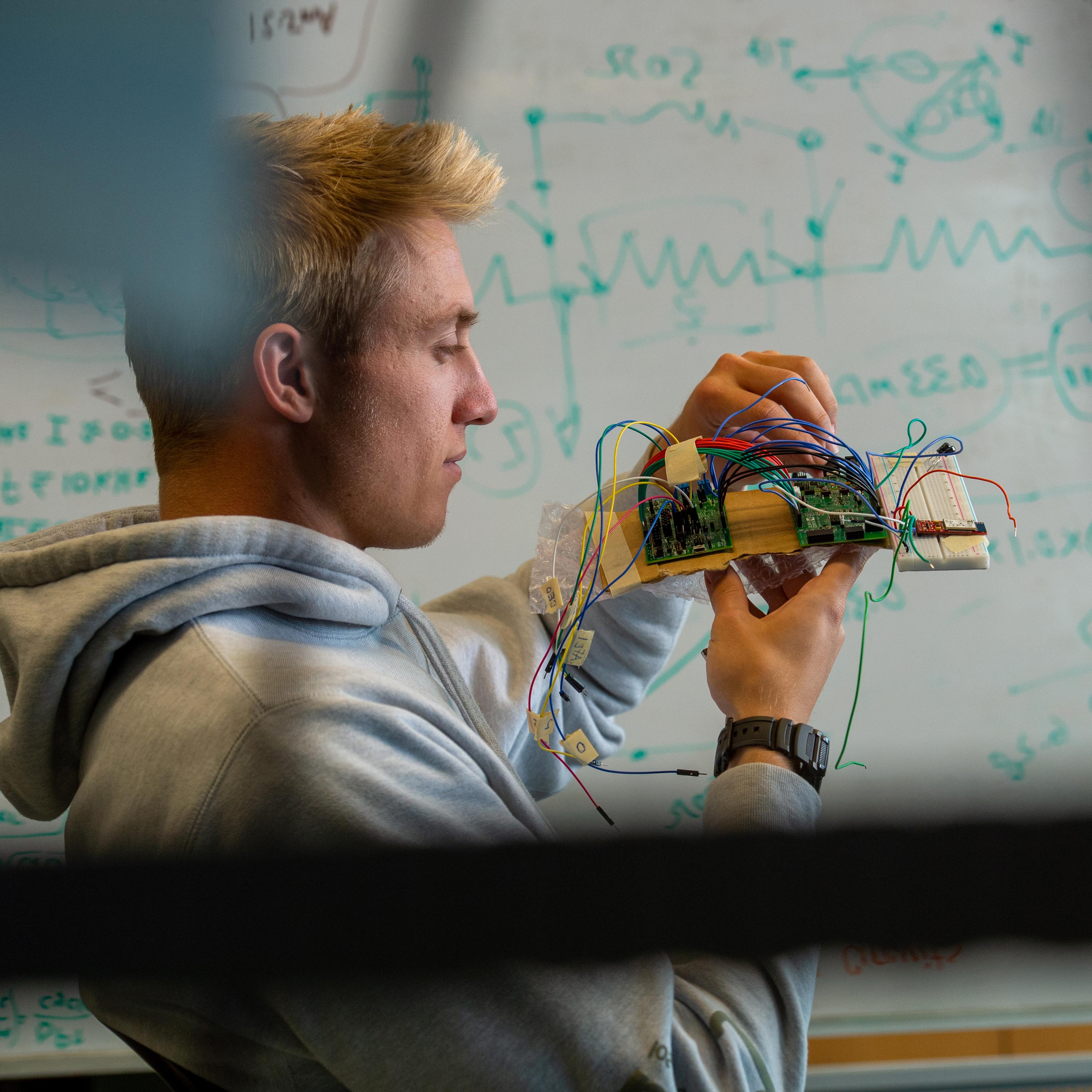 Student looking at computer board.